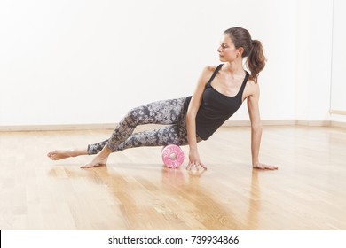 Beautiful woman pilates instructor stretching and warming up using foam roller
