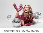 Beautiful woman in pink dress among disco balls on white background