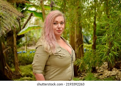 Beautiful Woman With Pink Hair Posing In Tropical Garden Standing  Wearing Dress Looking Away . Sexy Girl Nice Make Up Glamour Photography Outdoors