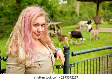 Beautiful Woman With Pink Hair Posing On A Farm Standing  Wearing Dress Looking At The Camera . Sexy Girl Nice Make Up Glamour Photography Outdoors