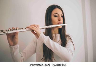 Beautiful Woman Playing The Flute. Female Musician With Her Instrument.