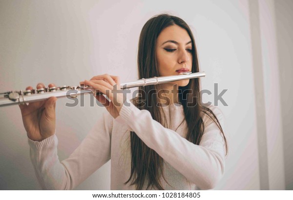 Beautiful woman playing the flute. Female\
musician with her\
instrument.