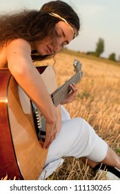 Beautiful Woman Playing Gitar On The Field