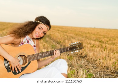 Beautiful Woman Playing Gitar On The Field