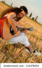 Beautiful Woman Playing Gitar On The Field