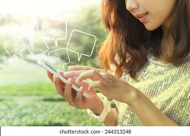 beautiful woman playing and touching on smart phone screen in outdoor of home garden field