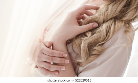 Beautiful woman portrait with perfect french manicure and long curly blond hair.Natural colors. Soft focus.