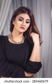 Beautiful woman portrait with professional make up. Model wearing black knitted sweater