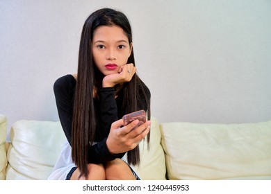 Beautiful woman posing - sitting on couch, sad, thinking, hand on chin - Shutterstock ID 1240445953