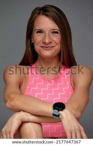 Similar – Close up front upper body portrait of one middle age athletic woman in sportswear in gym over dark background, looking at camera and smiling