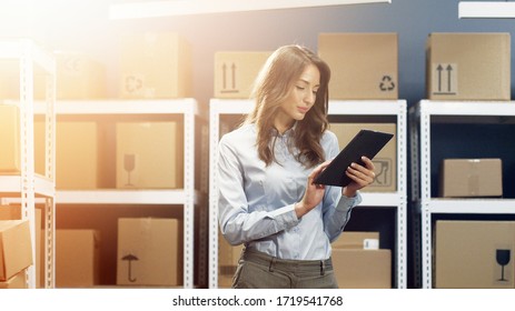 Beautiful Woman, Postal Worker With Tablet Device In Hands Working In Post Office.