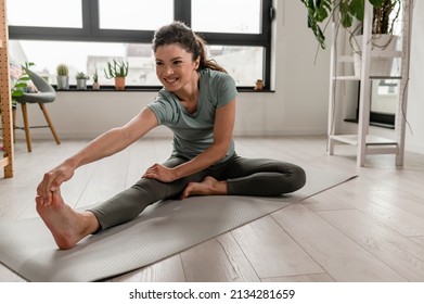 Beautiful Woman Practicing Yoga At Home, Trying To Get In Shape After Child Birth. Fitness Routines After 40