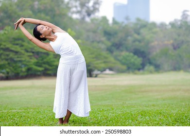 Beautiful woman practicing yoga in the park.Half Moon Pose / Ardha Chandrasana - Powered by Shutterstock