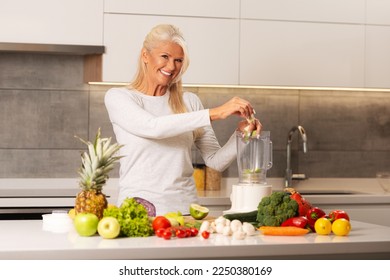 Beautiful woman preparing healthy and delicious green smoothie in a modern kitchen 
 - Powered by Shutterstock