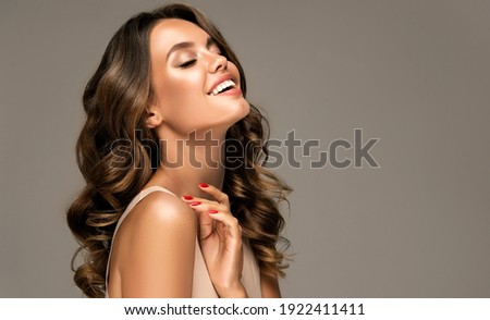 Photo of Beautiful woman in profile  with long  and   shiny wavy  hair .  Beauty  model girl with curly hairstyle .