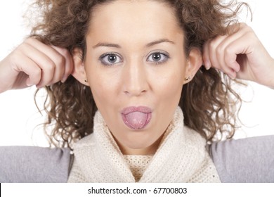 a beautiful woman is pulling her ears and making a funny face with her tong out