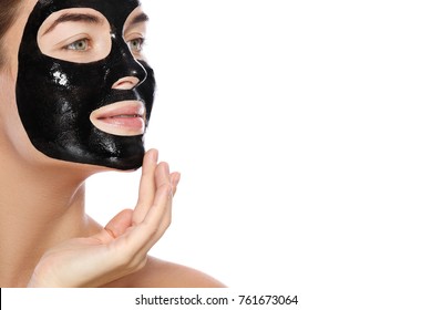 Beautiful Woman With A Purifying Black Mask On Her Face. Isolated On White Background