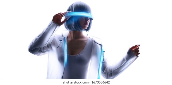 Beautiful Woman With Purple Hair In Futuristic Costume Over White Background. Girl In Glasses Of Virtual Reality. Augmented Reality, Game, Future Technology, AI Concept. VR. Blue Neon Light.