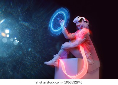 Beautiful woman with purple hair in futuristic costume on dark background. Girl in glasses of virtual reality. Augmented reality game, future technology, AI concept. Holographic interface.