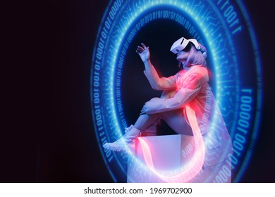 Beautiful woman with purple hair in futuristic costume on dark background. Girl in glasses of virtual reality. Augmented reality game, future technology, AI concept. Holographic interface.