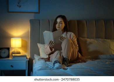 Beautiful woman reading before bed at night - Powered by Shutterstock