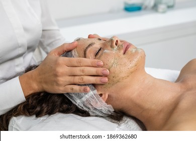 Beautiful Woman Receiving Natural Green Peel Facial Mask With Rejuvenating Effects In Spa Beauty Salon.