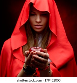 beautiful woman with red cloak holding apple