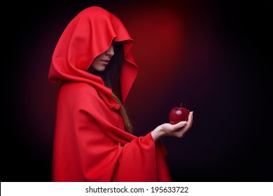 beautiful woman with red cloak holding apple in her hand