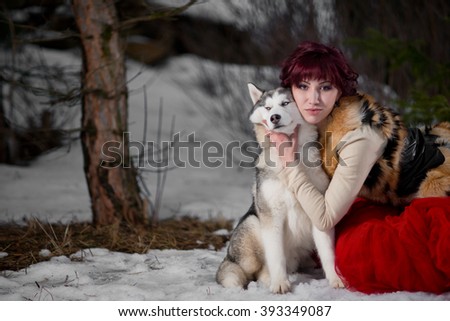 Beautiful woman in red dress with a husky dogs, looks like a wolfs