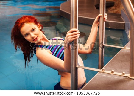 Beautiful woman with red hair relaxing in the pool. Spa beauty treatment and relaxation concept. Toned image