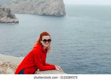 Beautiful woman in red hoodie on observation deck on Cape Formentor. Palma de Mallorca or Majorca, Balearic Islands, Spain