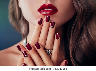 Beautiful Woman With Red Lips And Burgundy Manicure