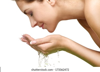 Beautiful woman refreshing her face with water on white