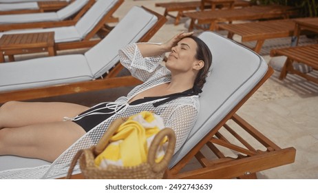 A beautiful woman relaxes on a sunlounger at a tropical bali resort, evoking luxury and tranquility. - Powered by Shutterstock