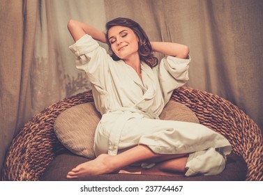 Beautiful woman relaxing in a bathrobe in spa salon 