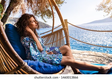 Beautiful woman relaxing on a bamboo swing chair under the olive trees in nice summer day, near the beach
 - Shutterstock ID 1460013866