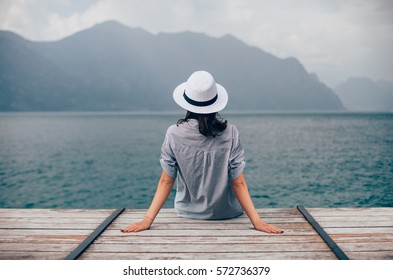 Beautiful woman relaxing on pier in Garda Lake. Vacation concept