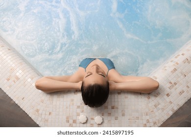 Beautiful woman relaxing in spa swimming pool, top view - Powered by Shutterstock