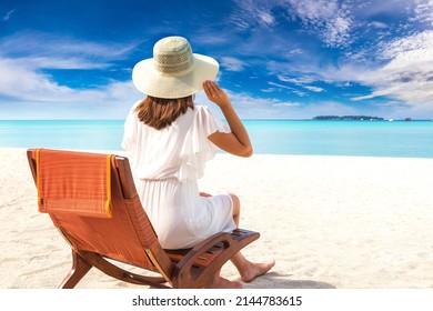 Beautiful Woman Relaxing In Sunbed At Luxury Tropical Beach In A Sunny Summer Day