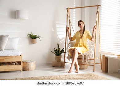 Beautiful woman resting in hammock chair at home