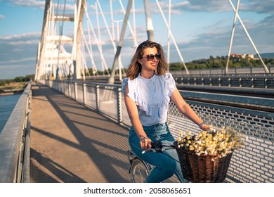 Beautiful Woman Riding Bicycle On Bridge. She Is Smiling And Enjoying Wonderful Day Alone