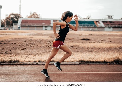 A beautiful woman runner is taking a strong stride for exercise. health care concept - Shutterstock ID 2043574601
