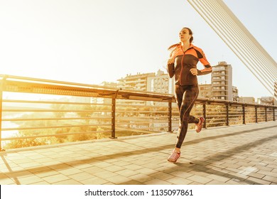 Beautiful Woman Running Over Bridge During Sunset