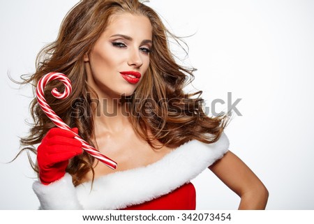 Beautiful woman with santa hat holding red-white Christmas Lollipop