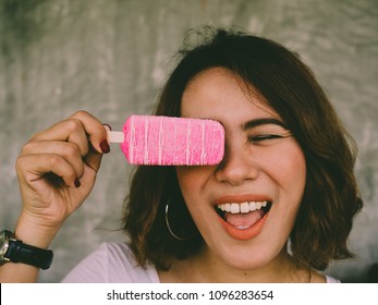 Beautiful Woman Short Hair Wearing White Shirt And Black Watch Holding Pink Popsicle Ice Pop By Right Hand With Happy Smiling On Summer Time