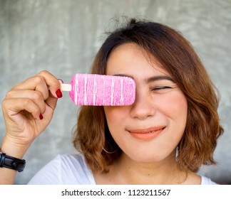 Beautiful Woman Short Hair Wearing White Shirt And Black Watch Holding Pink Popsicle Ice Pop By Right Hand With Happy Smiling On Summer Time