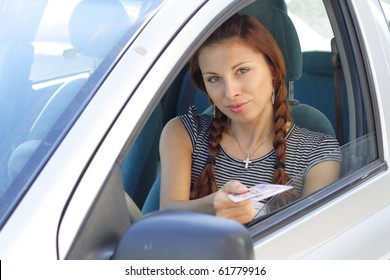 Beautiful woman show her driver's  licence in car. More images of this models you can find in my portfolio