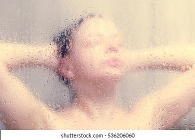 Beautiful Woman In The Shower Behind Glass With Drops