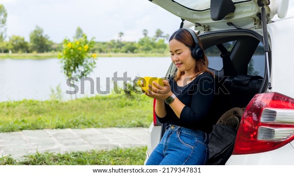 beautiful\
woman sitting at the back of a car drinking\
tea