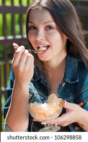 Beautiful Woman Sitting In Cafe And Eating Ice Cream From Glass Bowl